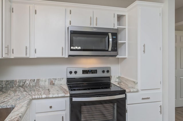 kitchen with open shelves, white cabinets, stainless steel microwave, and range with electric cooktop