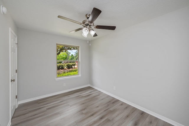 unfurnished room with baseboards, light wood-style flooring, and ceiling fan