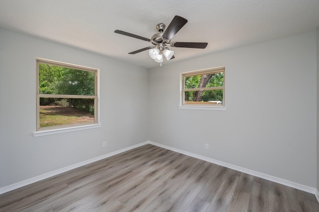 empty room featuring baseboards, ceiling fan, and wood finished floors