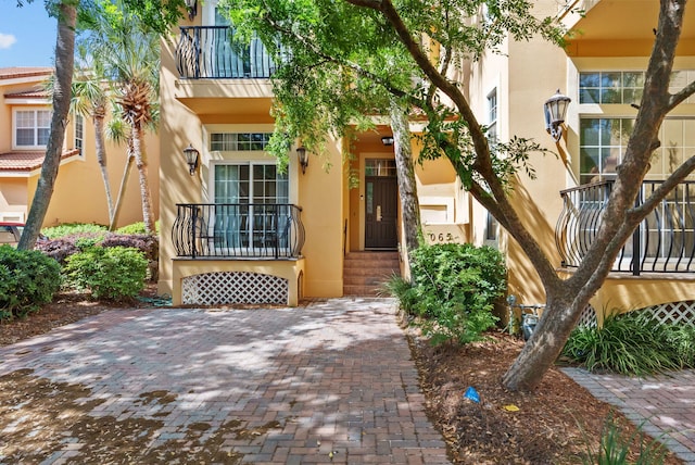 property entrance featuring a balcony and stucco siding