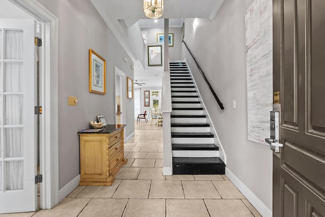foyer featuring stairway, baseboards, and light tile patterned floors