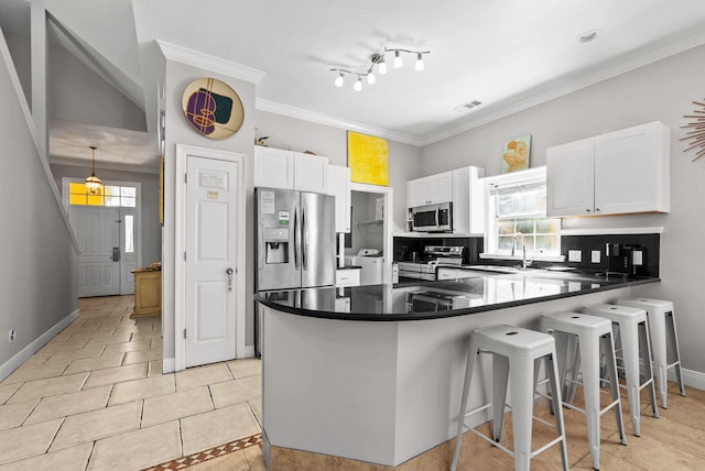 kitchen featuring a peninsula, white cabinets, visible vents, appliances with stainless steel finishes, and a sink