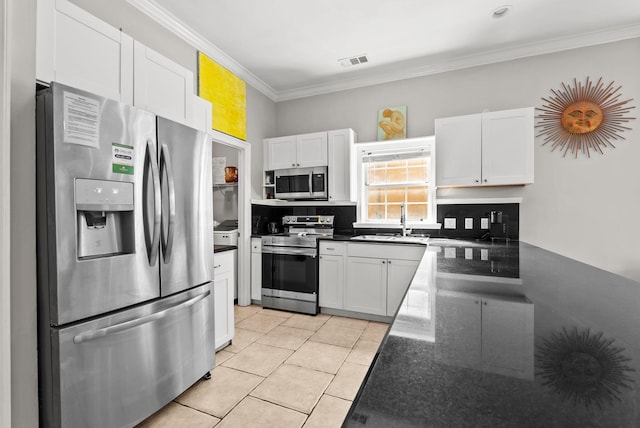 kitchen with stainless steel appliances, white cabinets, a sink, and ornamental molding