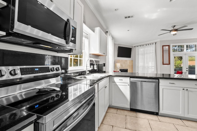 kitchen with ornamental molding, backsplash, visible vents, appliances with stainless steel finishes, and a sink