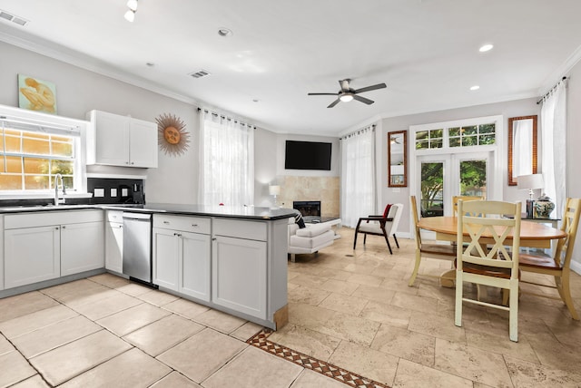 kitchen with a peninsula, a ceiling fan, visible vents, a sink, and dark countertops