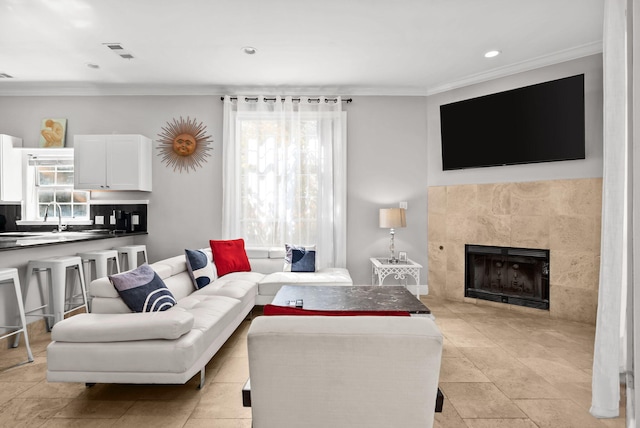 living room with ornamental molding, visible vents, recessed lighting, and a fireplace