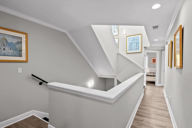 stairway with wood finished floors, baseboards, and visible vents