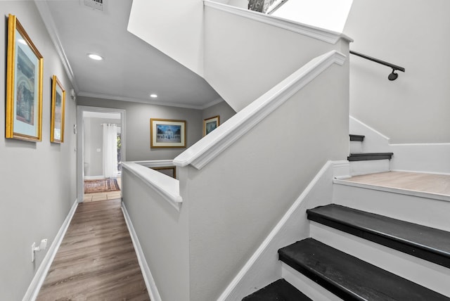 stairway with baseboards, ornamental molding, recessed lighting, visible vents, and wood finished floors