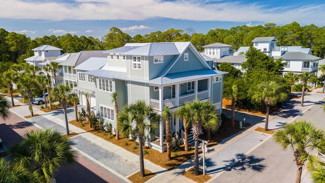 272 Beach Bike Way, Seacrest, FL 32461 - rear view of house featuring driveway, metal roof, a garage, a standing seam roof, and a residential view