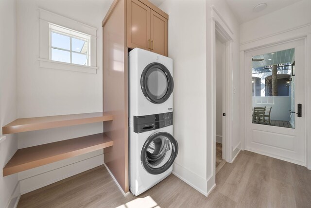 272 Beach Bike Way, Seacrest, FL 32461 - laundry room featuring stacked washer / dryer, light wood finished floors, and baseboards