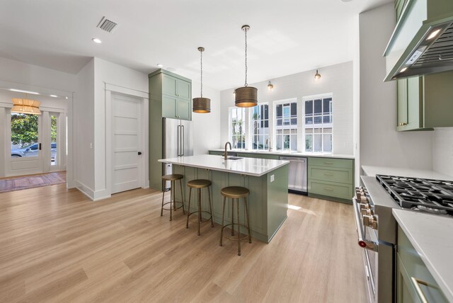 272 Beach Bike Way, Seacrest, FL 32461 - kitchen with green cabinets, custom exhaust hood, high end appliances, a breakfast bar, and light wood-type flooring