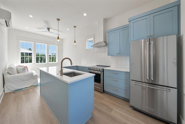 272 Beach Bike Way, Seacrest, FL 32461 - kitchen featuring appliances with stainless steel finishes, a sink, wall chimney range hood, a wall unit AC, and decorative backsplash