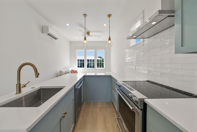 272 Beach Bike Way, Seacrest, FL 32461 - kitchen featuring a sink, stainless steel appliances, wall chimney range hood, an AC wall unit, and decorative backsplash