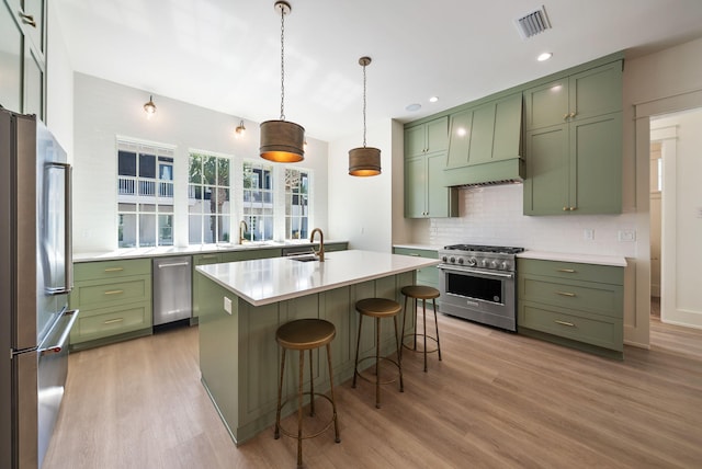 272 Beach Bike Way, Seacrest, FL 32461 - kitchen featuring green cabinets, high quality appliances, light wood-style floors, custom exhaust hood, and light countertops