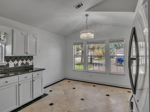 27 Hidden Harbor Ln, Miramar Beach, FL 32550 - kitchen featuring freestanding refrigerator, vaulted ceiling, light tile patterned flooring, decorative backsplash, and white cabinetry