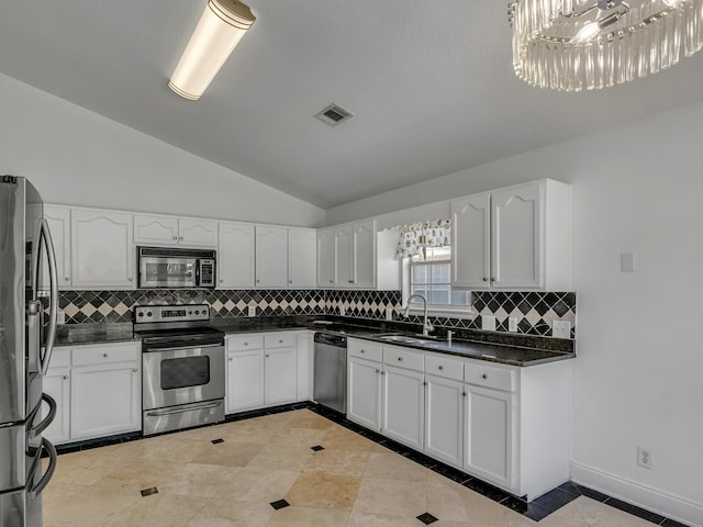 27 Hidden Harbor Ln, Miramar Beach, FL 32550 - kitchen with stainless steel appliances, a sink, vaulted ceiling, dark countertops, and white cabinets