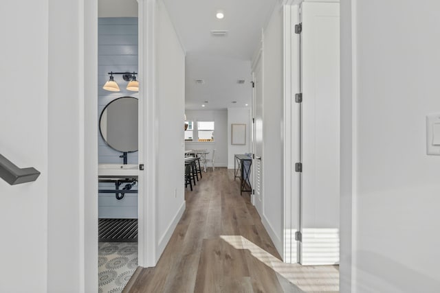 hall featuring wood finished floors and visible vents