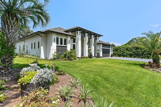 view of front of home featuring driveway, an attached garage, and a front lawn