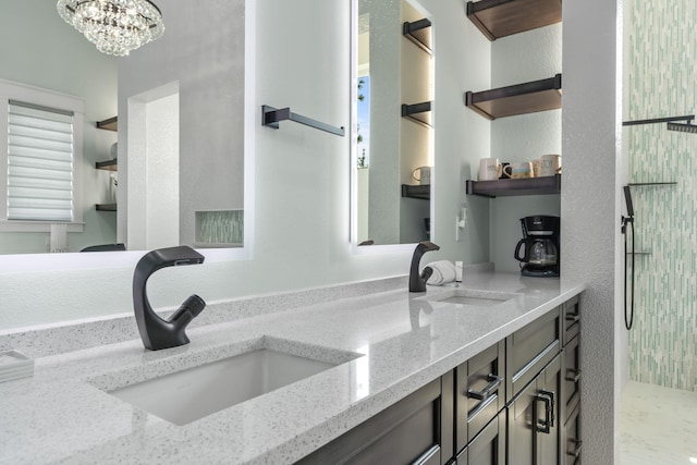 bathroom with a sink, double vanity, and an inviting chandelier