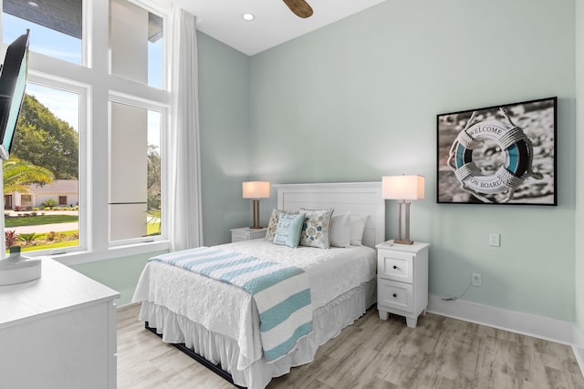 bedroom with light wood-style floors, baseboards, and recessed lighting