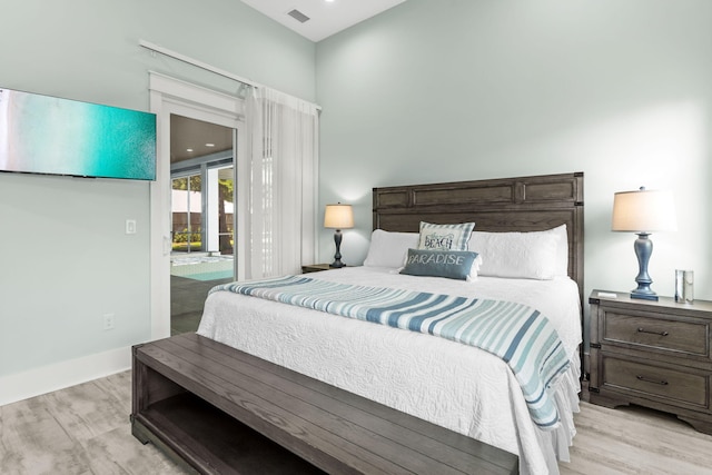 bedroom featuring baseboards, light wood-style floors, access to exterior, and visible vents