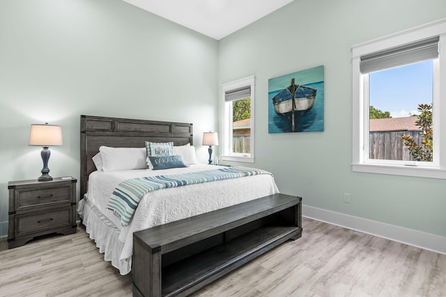 bedroom featuring light wood finished floors and baseboards
