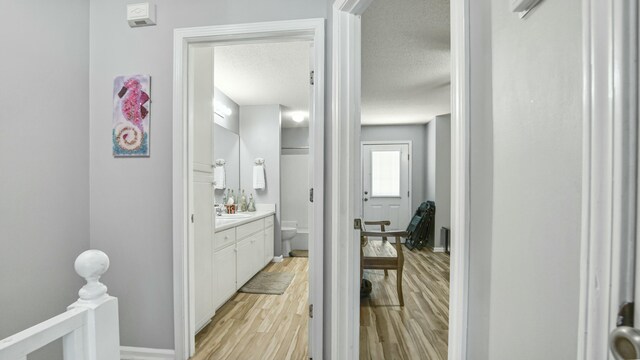 bathroom featuring baseboards, toilet, a textured ceiling, vanity, and wood finished floors