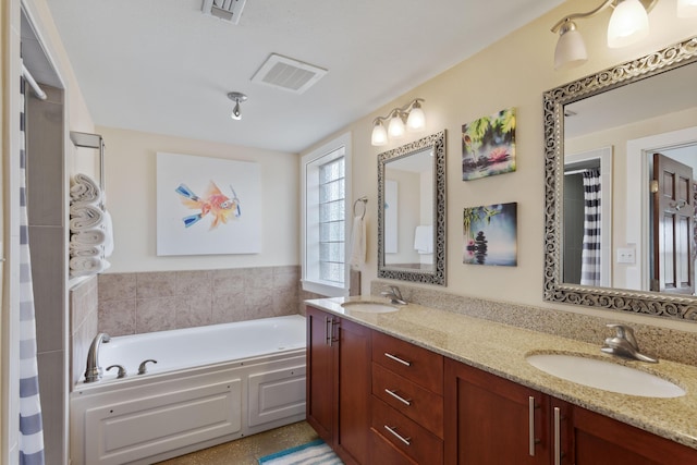 bathroom with visible vents, a sink, a garden tub, and double vanity