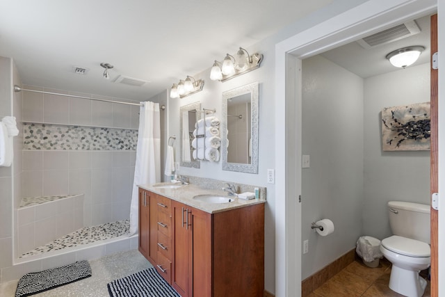 full bath featuring a sink, a tile shower, and visible vents