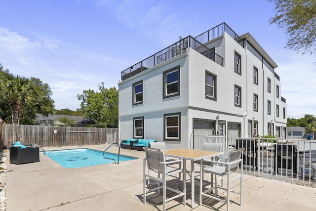 view of pool featuring a patio, outdoor lounge area, fence, and a fenced in pool