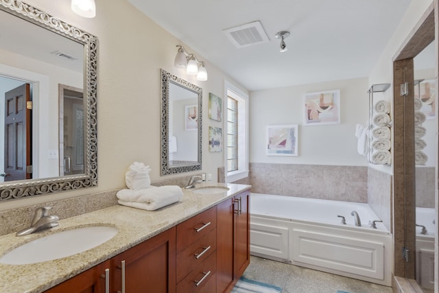 bathroom featuring double vanity, visible vents, a sink, and a bath