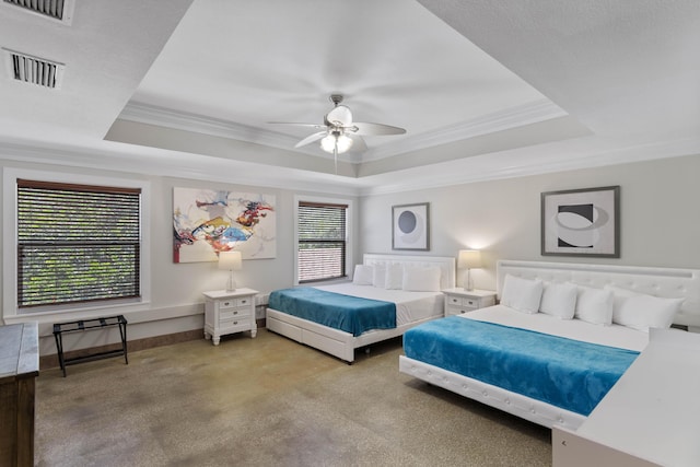carpeted bedroom featuring ornamental molding, a tray ceiling, ceiling fan, and visible vents