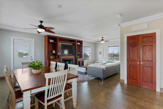 dining area with baseboards, a ceiling fan, and a fireplace