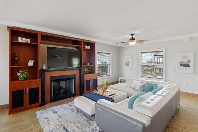 living room featuring baseboards, a ceiling fan, and a fireplace