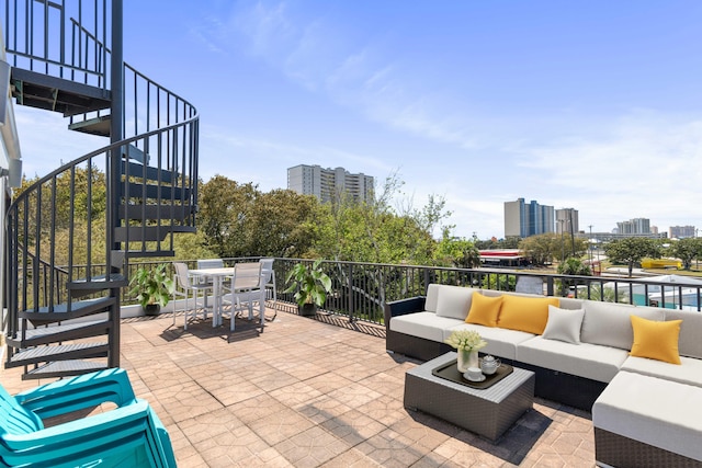 view of patio / terrace featuring stairway, outdoor lounge area, a city view, and outdoor dining area