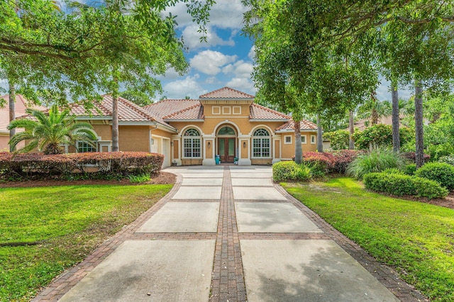 4594 Nautical Ct, Destin, FL 32541 - mediterranean / spanish-style house featuring stucco siding, an attached garage, a tile roof, and a front lawn