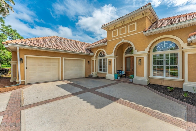 4594 Nautical Ct, Destin, FL 32541 - mediterranean / spanish-style house featuring a garage, stucco siding, driveway, and a tile roof