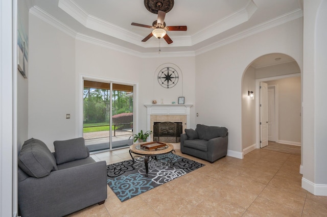 4594 Nautical Ct, Destin, FL 32541 - living room with crown molding, arched walkways, a ceiling fan, a tile fireplace, and a tray ceiling