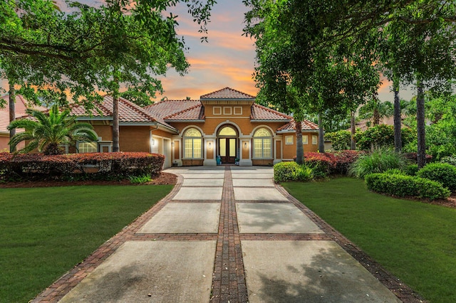 4594 Nautical Ct, Destin, FL 32541 - mediterranean / spanish house with a tile roof, driveway, a lawn, a garage, and stucco siding