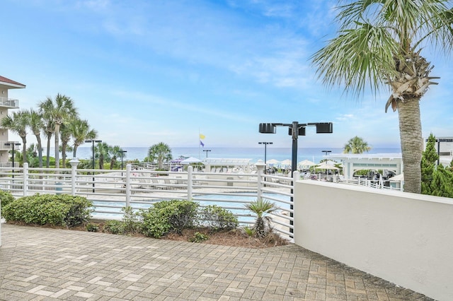 view of patio with fence and a water view