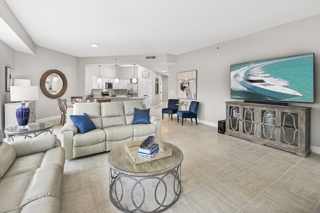 living room featuring visible vents, baseboards, and light tile patterned flooring