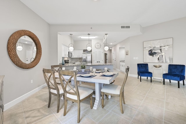 dining room featuring light tile patterned floors, visible vents, and baseboards