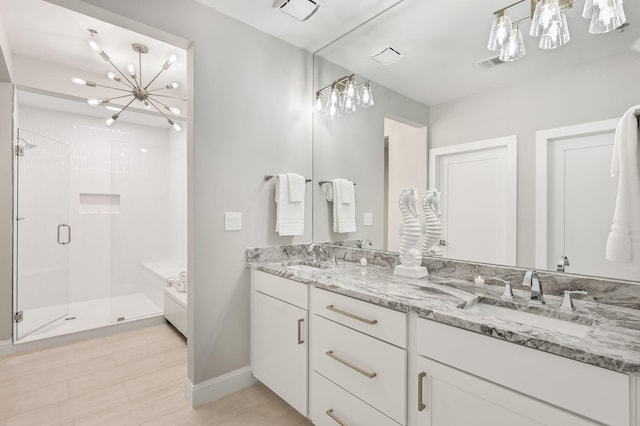 full bathroom featuring a shower stall, an inviting chandelier, a sink, and visible vents
