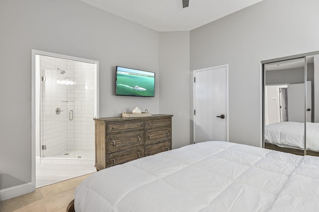 bedroom with ensuite bathroom, tile patterned floors, a ceiling fan, and baseboards
