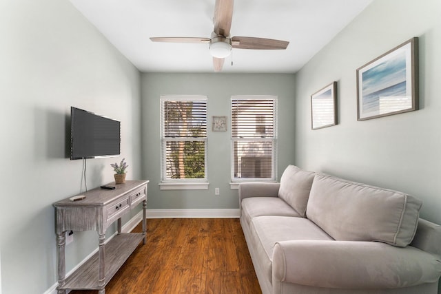 living area featuring dark wood-style flooring, baseboards, and a ceiling fan