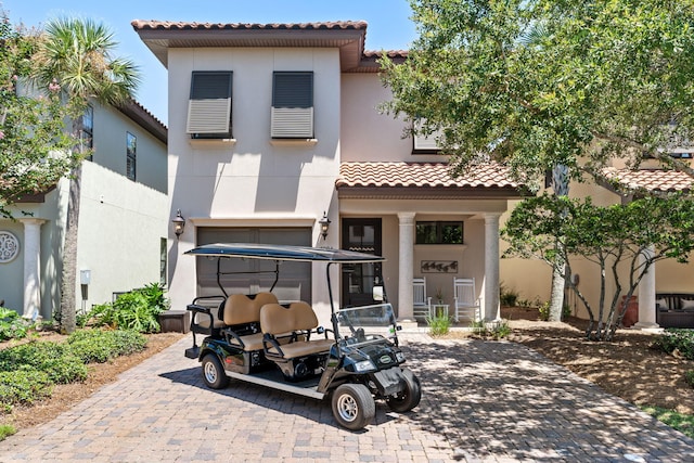 rear view of house featuring a tiled roof and stucco siding