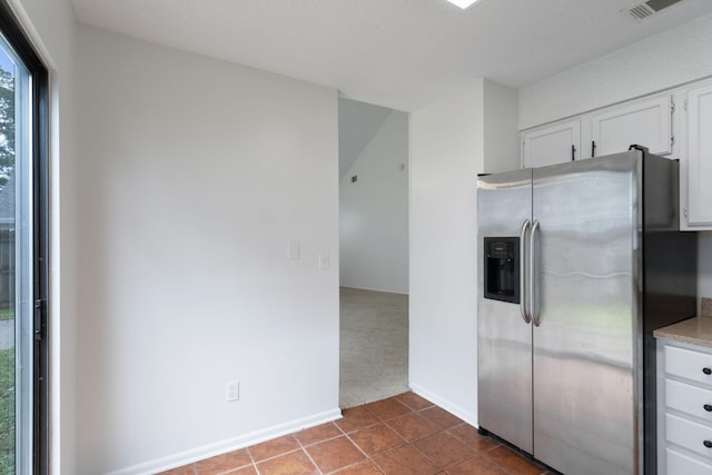 2106 Wilderness Path, Fort Walton Beach, FL 32547 - kitchen with stainless steel refrigerator with ice dispenser, white cabinets, dark tile patterned floors, dark colored carpet, and light countertops