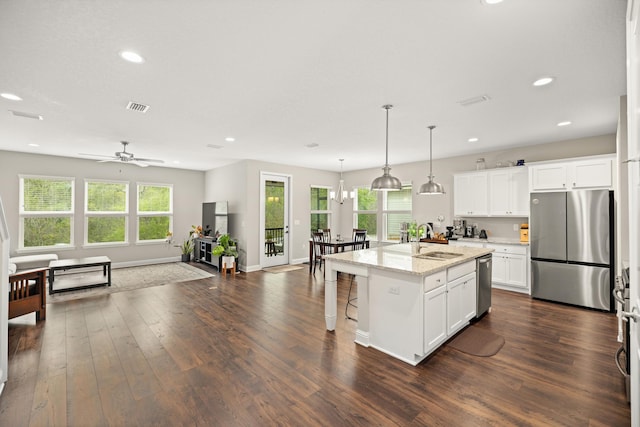 kitchen with dark wood finished floors, visible vents, appliances with stainless steel finishes, a sink, and open floor plan