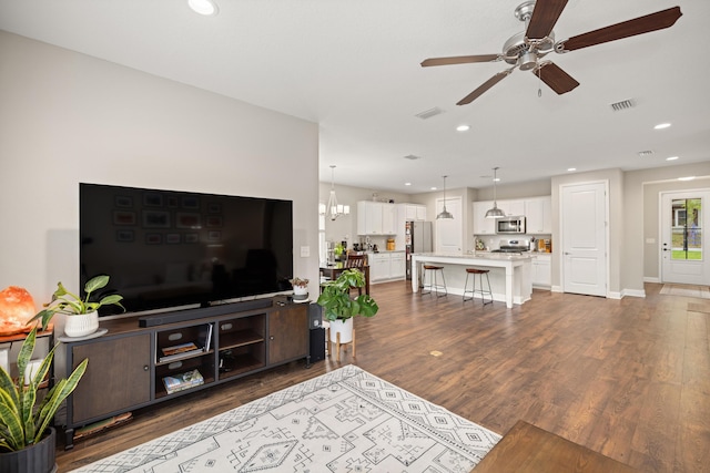 living area with dark wood-type flooring, visible vents, ceiling fan, and recessed lighting