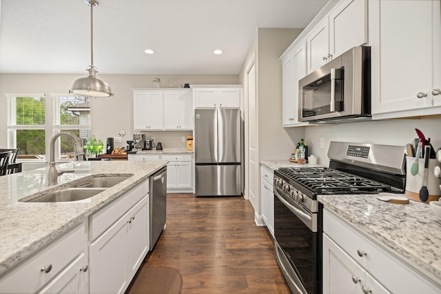 kitchen featuring dark wood-style flooring, white cabinetry, a sink, and appliances with stainless steel finishes